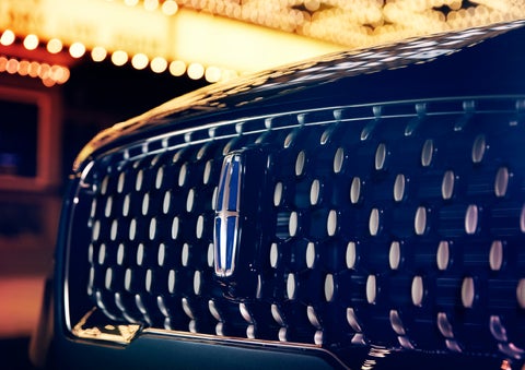 The Corsair Grand Touring grille shows floating chrome ovals that catch the glowing light of a theater marquee and frame the distinctive Lincoln Star | Empire Lincoln in Abingdon VA