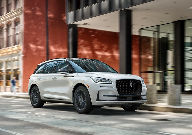 The 2024 Lincoln Corsair® SUV with the Jet Appearance Package and a Pristine White exterior is parked on a city street. | Empire Lincoln in Abingdon VA