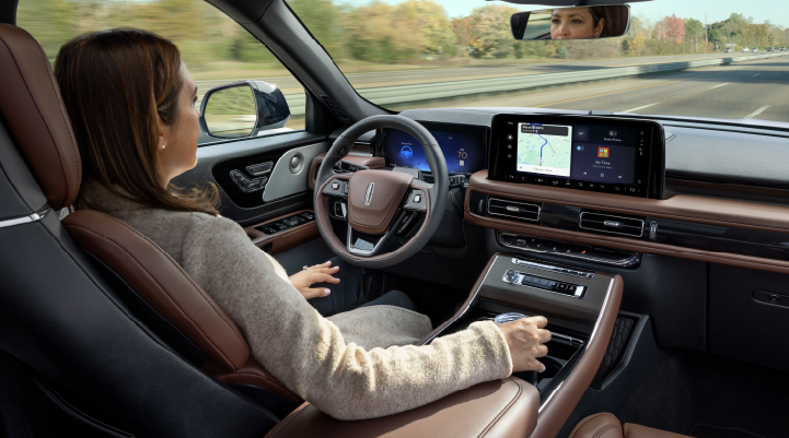 A woman is seen sitting in the driver’s seat of her 2025 Lincoln Aviator® SUV with her hands off the steering wheel. | Empire Lincoln in Abingdon VA